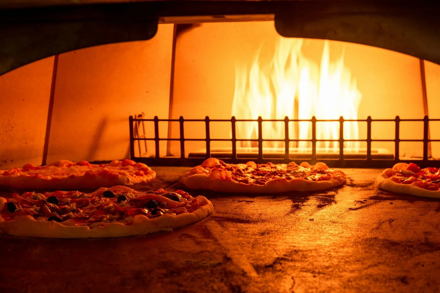 Pizzas horneándose en un horno de leña
